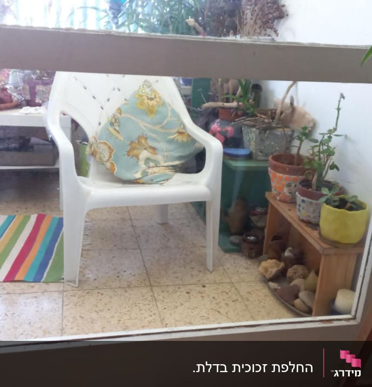 דלת זכוכית עם מסגרת לבנה במרפסת